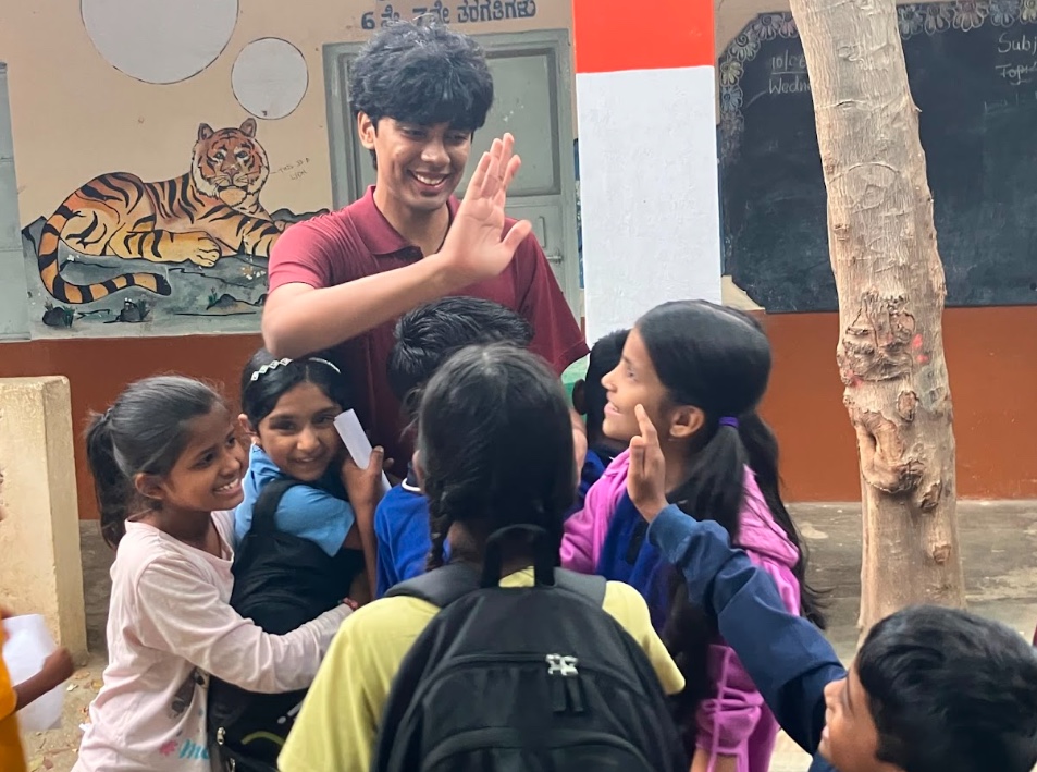 A CareForAll volunteer with children at a school